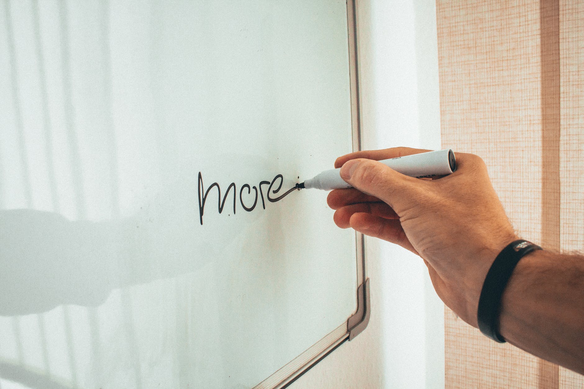 crop male employee writing on whiteboard in office